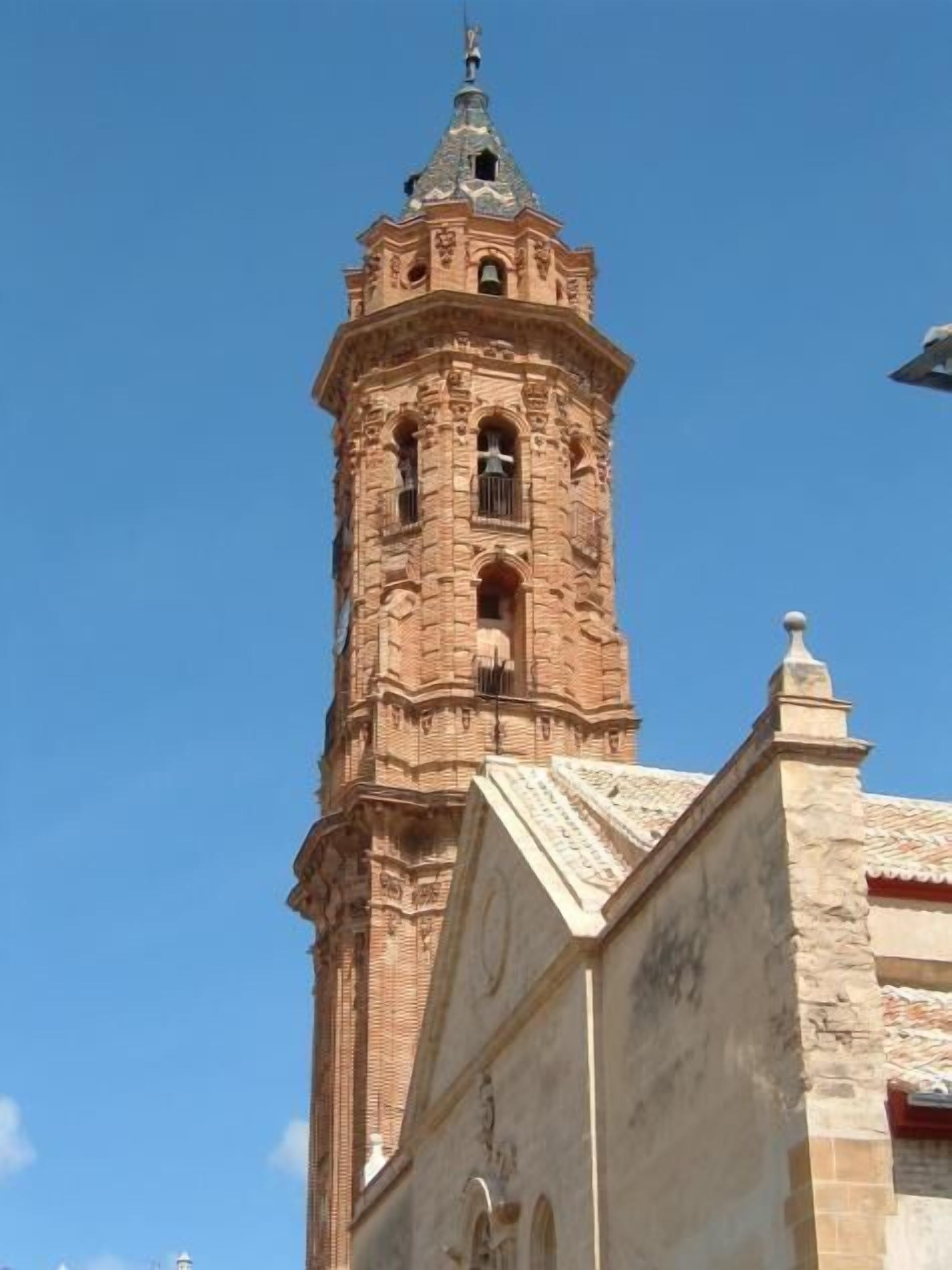 A historic building with a prominent clock tower and a large arched doorway.