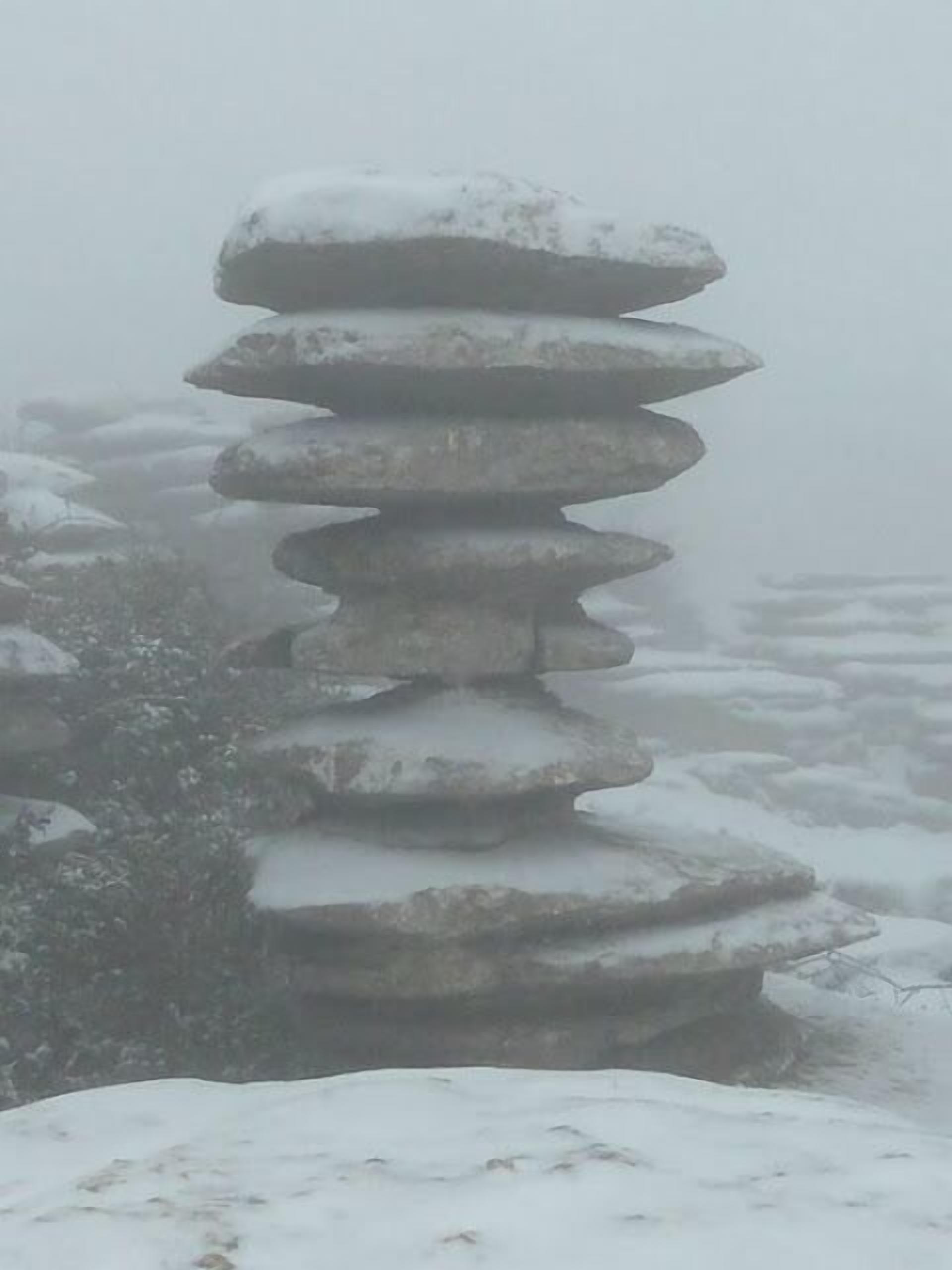 A stone cairn in a snowy landscape.