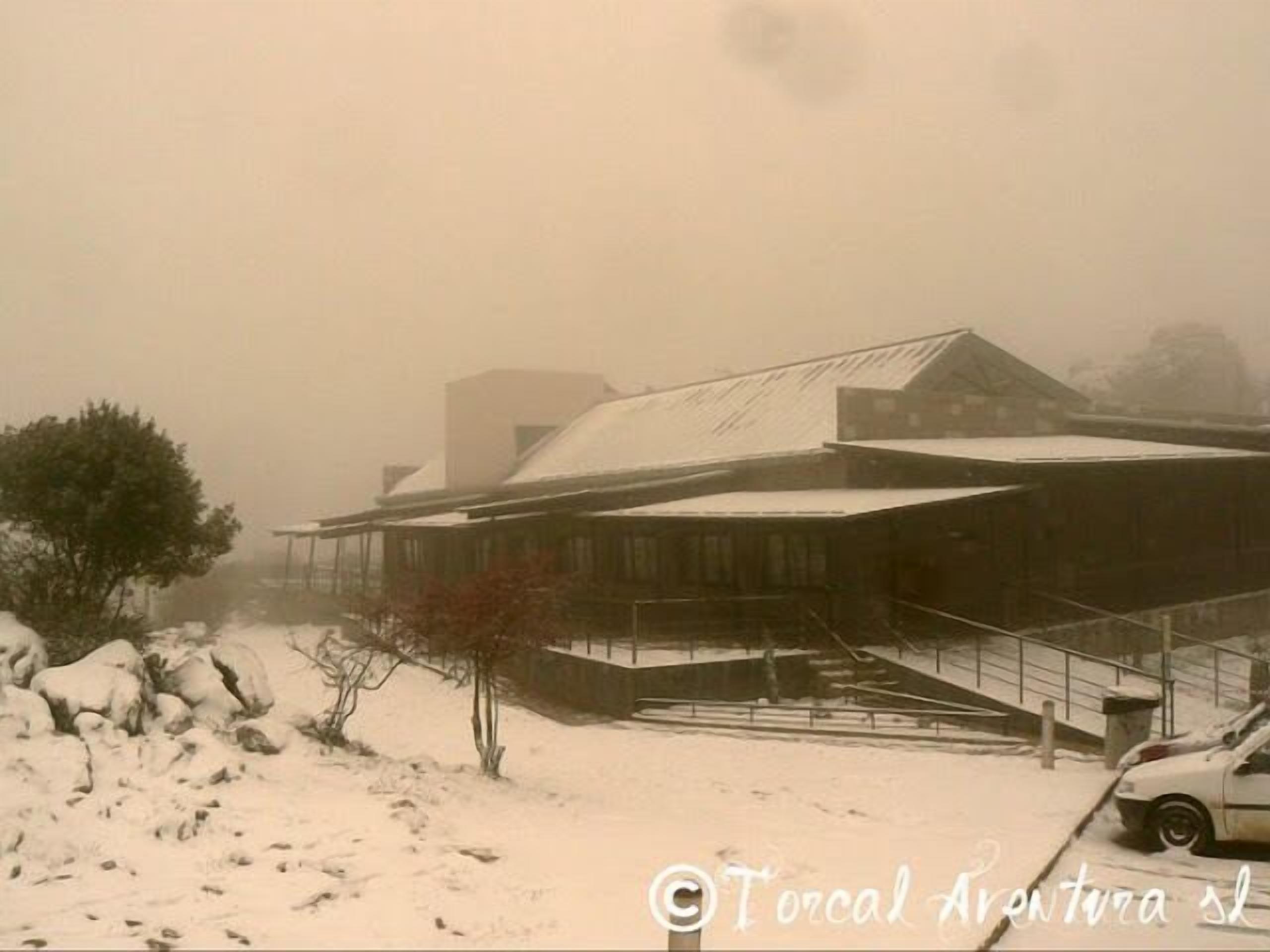 A building with a sloped roof and a staircase leading to the entrance.