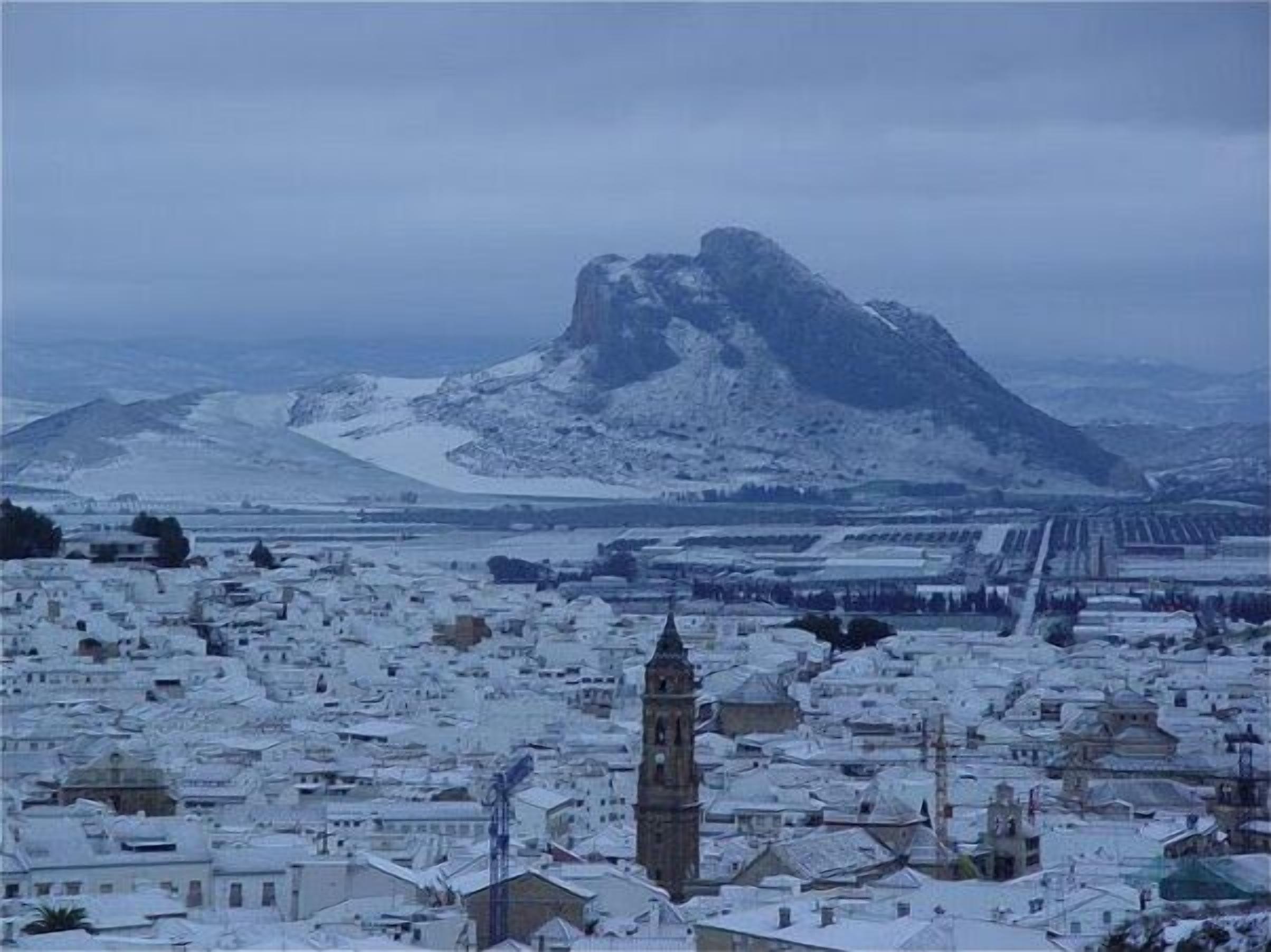 A town with snow-covered buildings and a prominent tower.