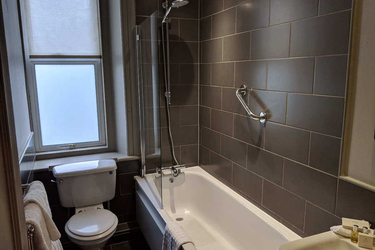 standard double room single use, 1 large single bed | bathroom | combined shower/bathtub, free toiletries, hair dryer, towels