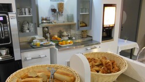 Een ontbijtbuffet met brood, gebak en fruit.
