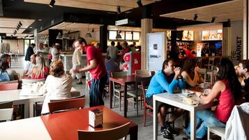 Un restaurante concurrido con varias mesas y sillas, una barra con un menú y un letrero que dice 'The Market'.