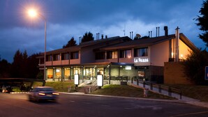 A building with a sign reading "La Pausa" at night, featuring a ramp and a parking lot. - As Hoteles Altube (Zuia)