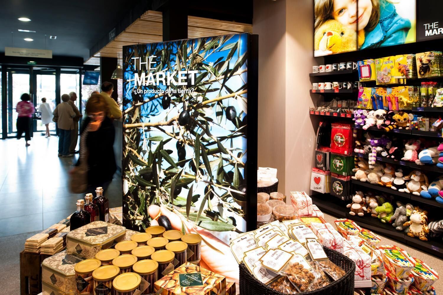 A market display with olive oil bottles and packaged food items.