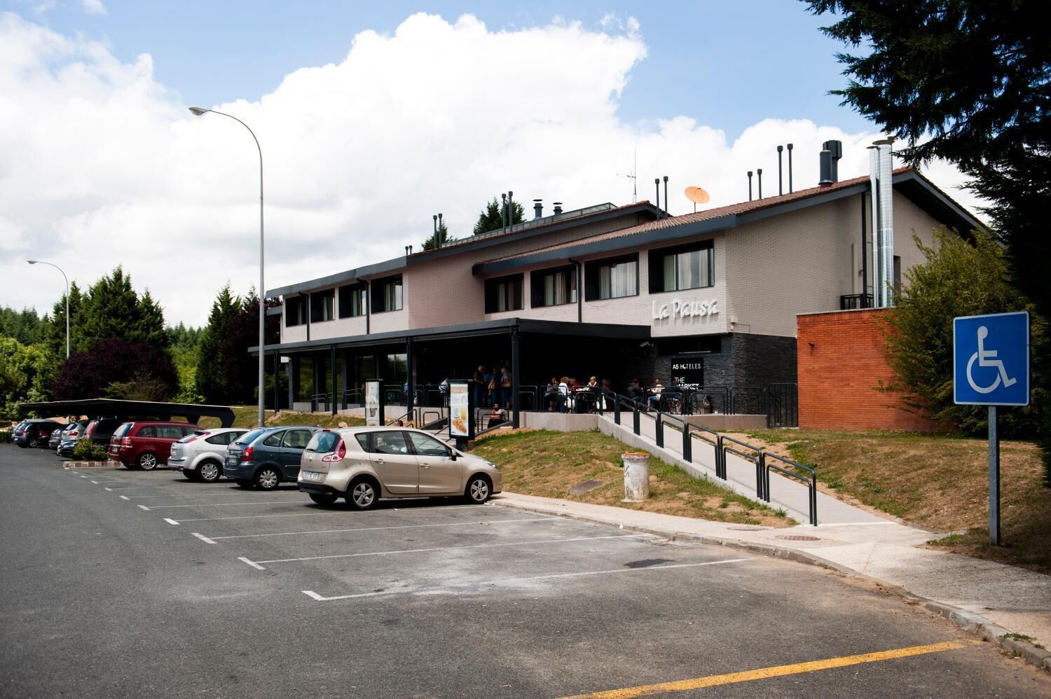 A building with a sign reading "La Pause" and a handicapped accessibility sign.