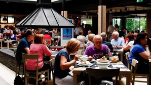 A spacious indoor dining area with high ceilings and large windows, allowing natural light to fill the space. - As Hoteles Altube (Zuia)