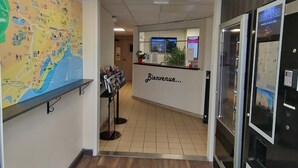 Un espace d’accueil comprenant un plan, un comptoir d’information et un réfrigérateur.