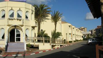 Un hotel de fachada color crema, con ventanas arqueadas y un letrero que dice "Havillas la Manga".