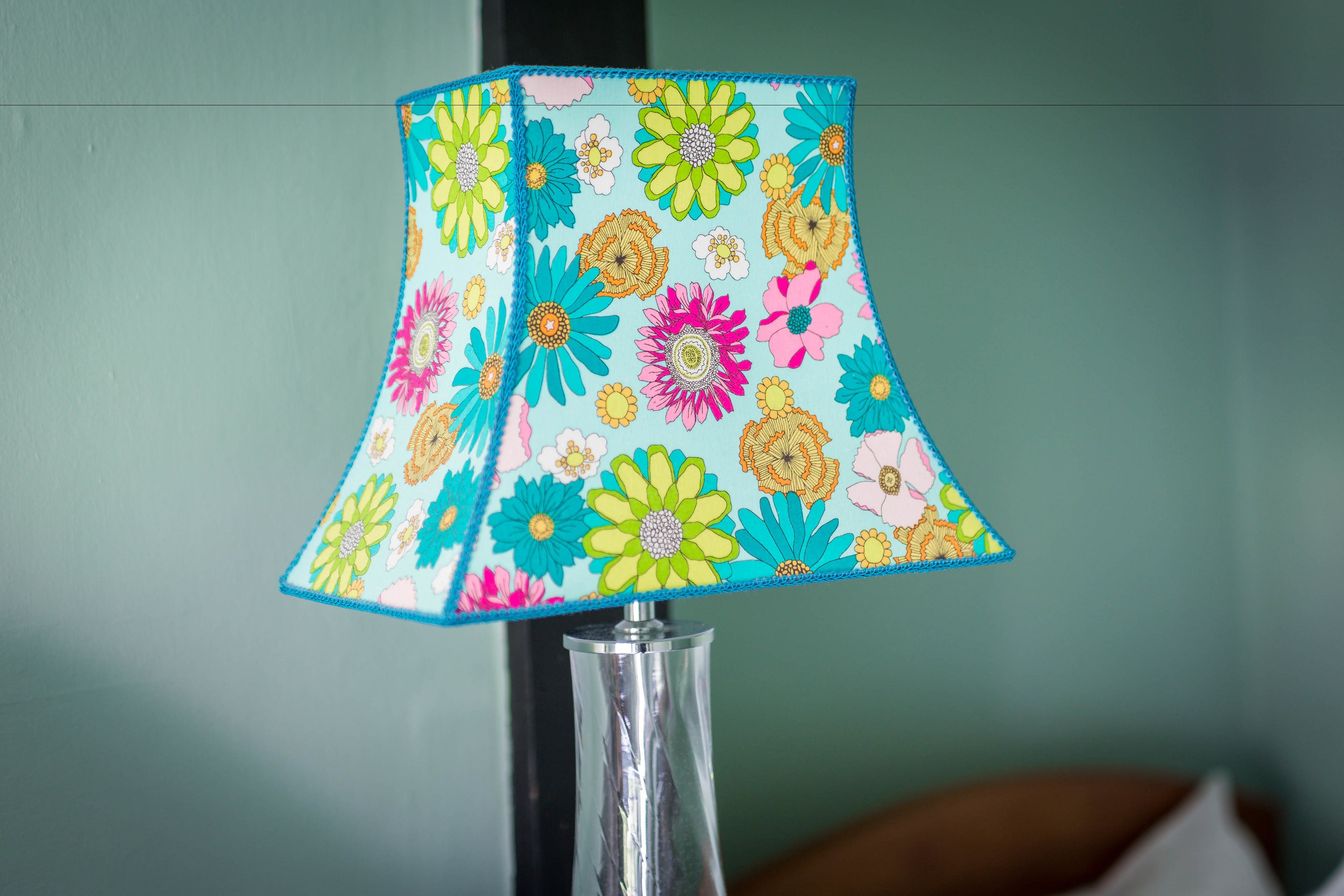 A lamp with a colorful floral pattern on its lampshade.