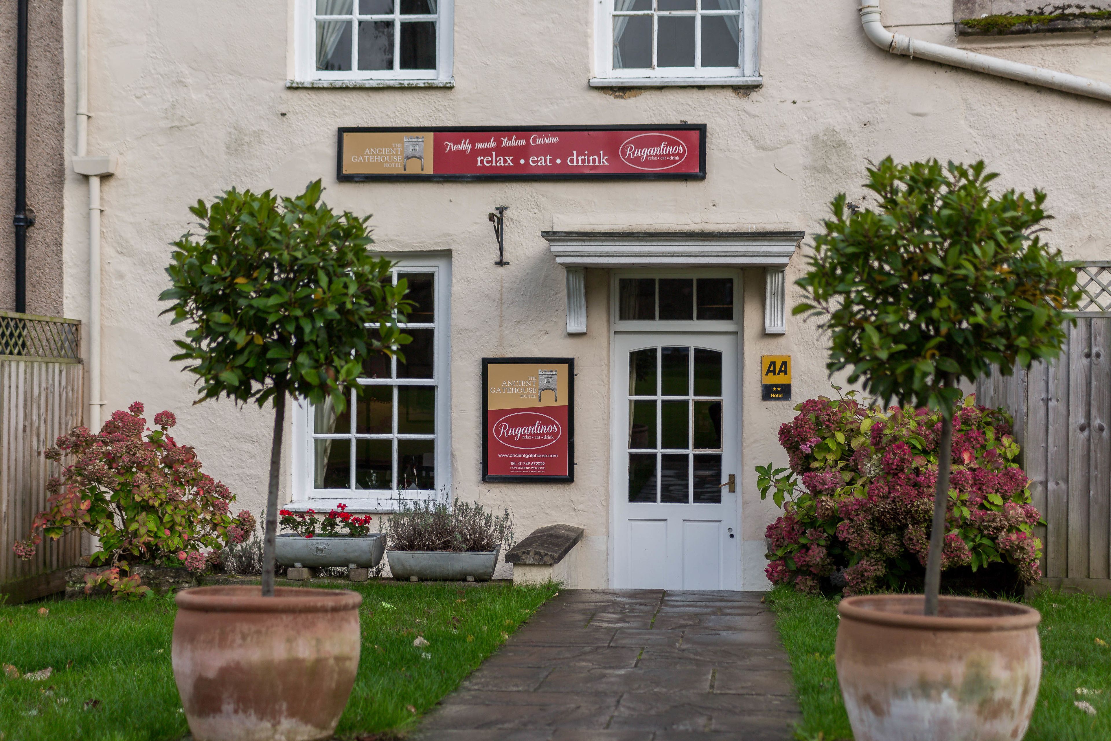 Un edificio con un cartel que dice 'Rugantino's' y una placa que indica 'Ancient House Hotel'.