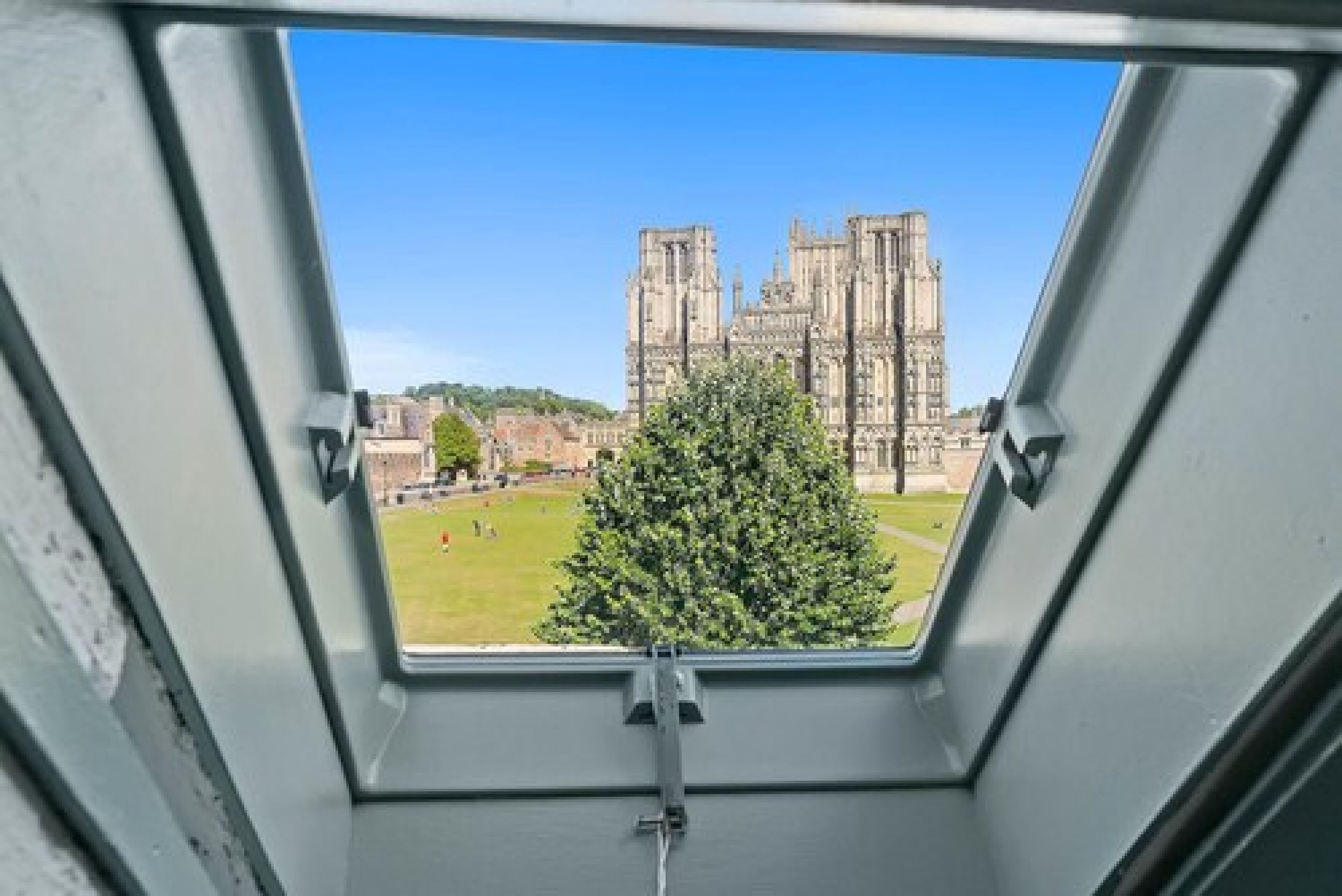 A view through a skylight of a large, historic building with multiple towers.
