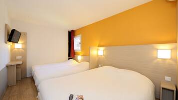 A hotel room with two beds, a TV mounted on the wall, and bedside lamps.