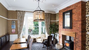 A cozy room with a fireplace, seating area, and a view of the outdoors. - Hedley House Hotel Wellness and Spa (York)