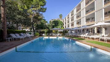 Una piscina al aire libre de temporada, sillones reclinables de piscina