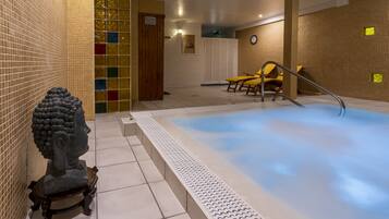 Zona de spa con hidromasaje, asientos y una estatua.