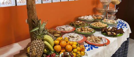 Una mesa de buffet con diferentes alimentos y un tronco de árbol decorativo.
