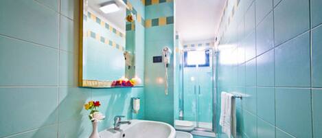 Un baño con lavabo, espejo, inodoro y ducha.
