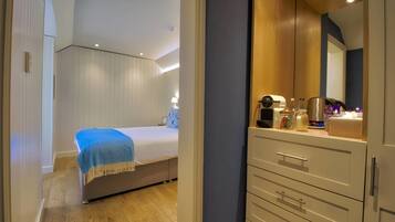 A bedroom with a bed, bedside table, and a dresser with drawers.