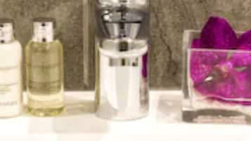 A bathroom sink with three bottles of liquid soap and a dispenser.