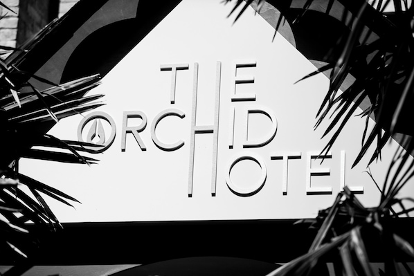 A sign with the text 'THE ORCHID HOTEL' surrounded by foliage. - The Orchid Hotel (Bournemouth)