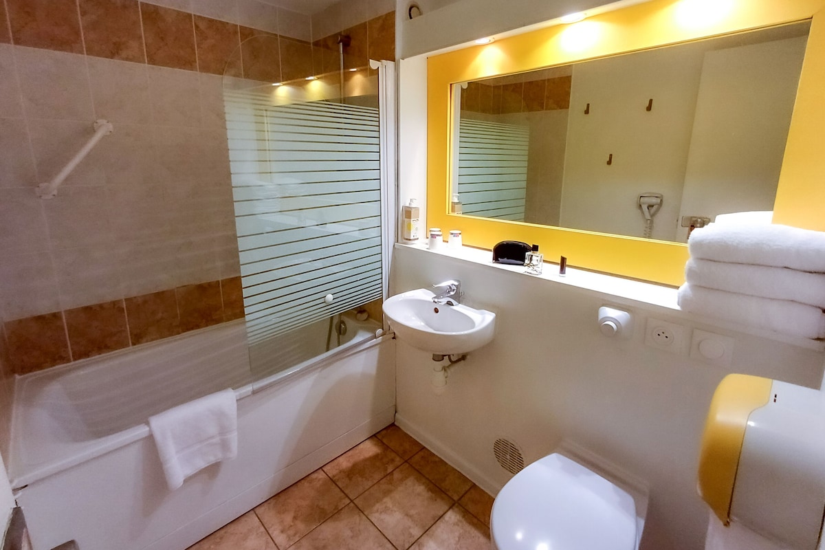 Een badkamer met een bad, een wastafel, een toilet en een spiegel.