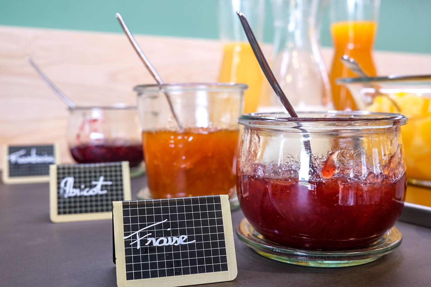Three glass containers with straws, each labeled with a different name.