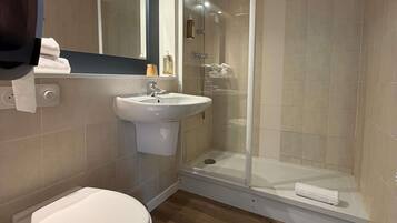 A bathroom with a toilet, sink, and glass-enclosed shower.