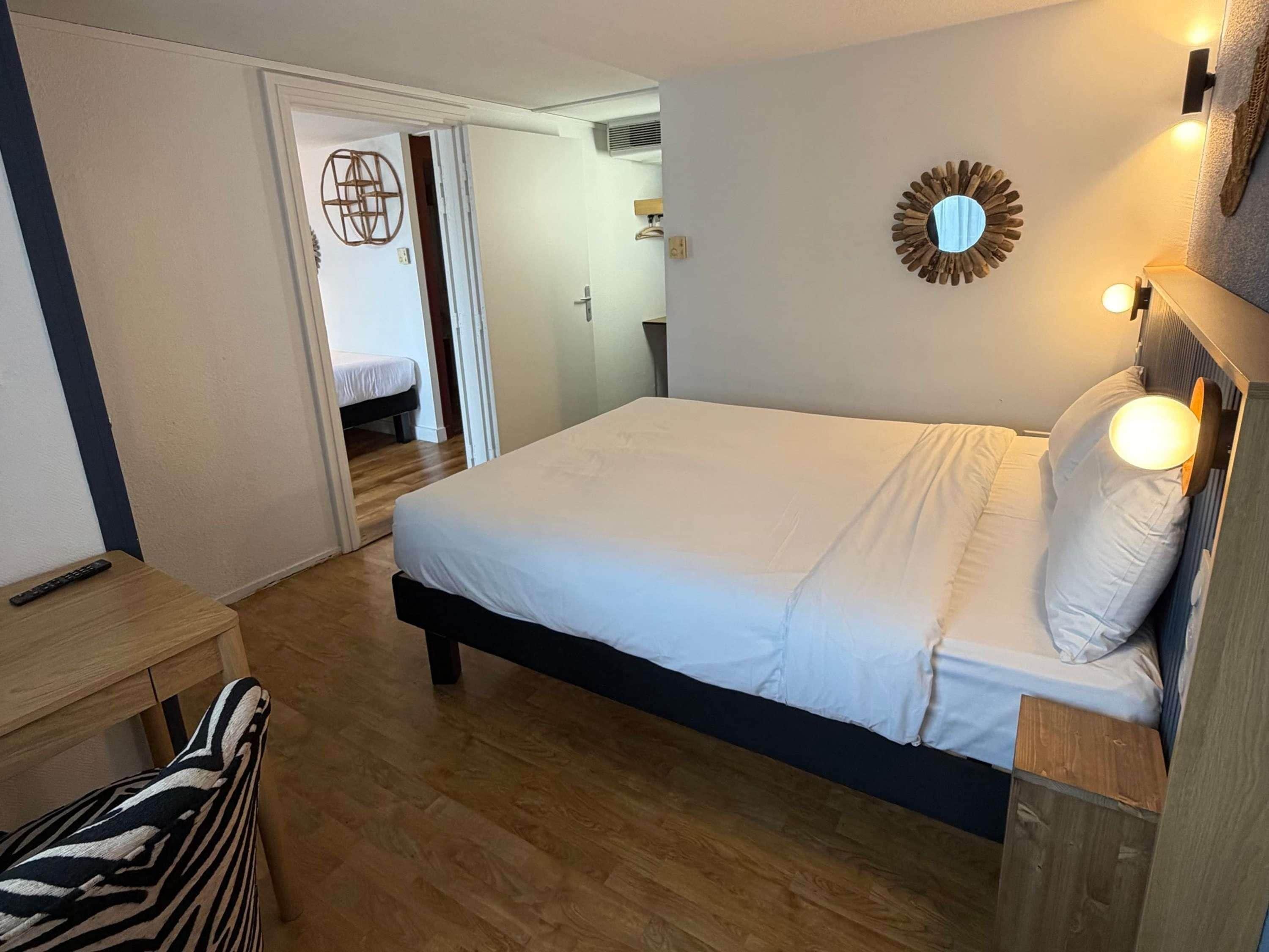 A bedroom with a bed, bedside table, and a lamp.