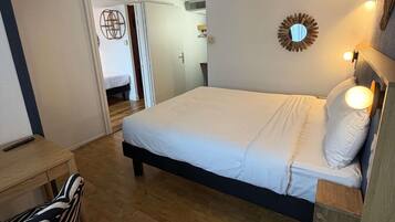 Une chambre à coucher avec un lit, une table de chevet et une lampe.