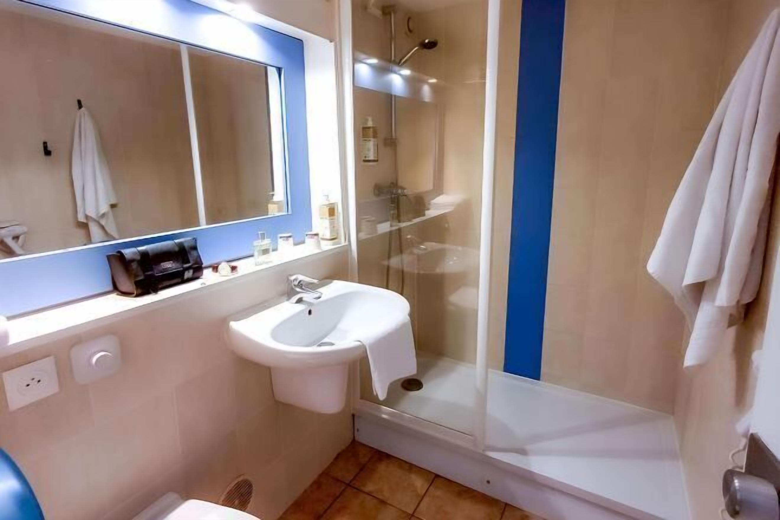 Badkamer | Een douche, een haardroger, handdoeken