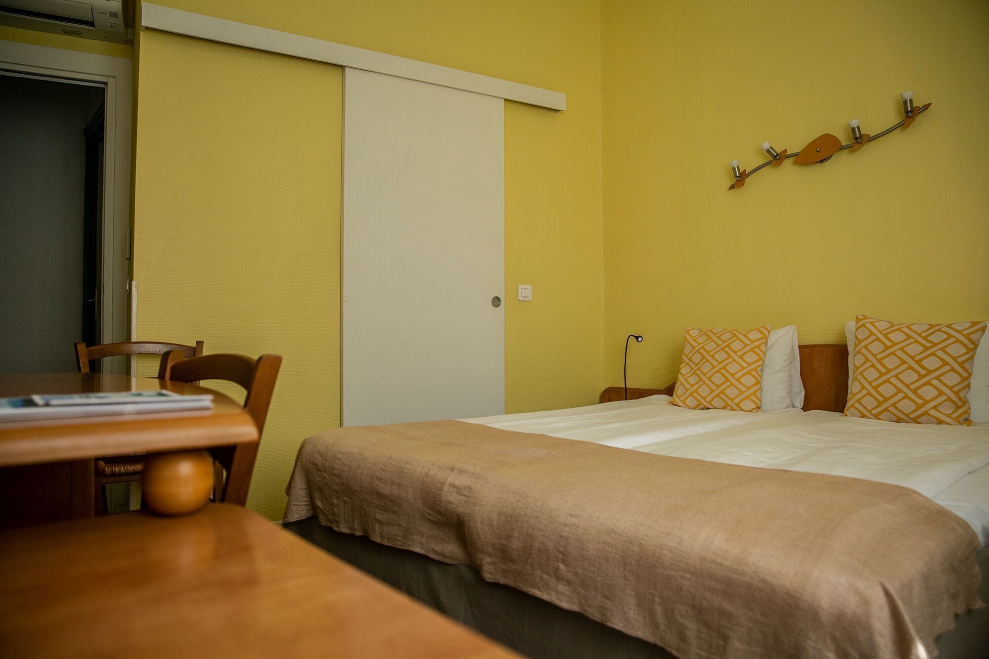Une chambre d’hôtel avec un lit, un bureau et une chaise.