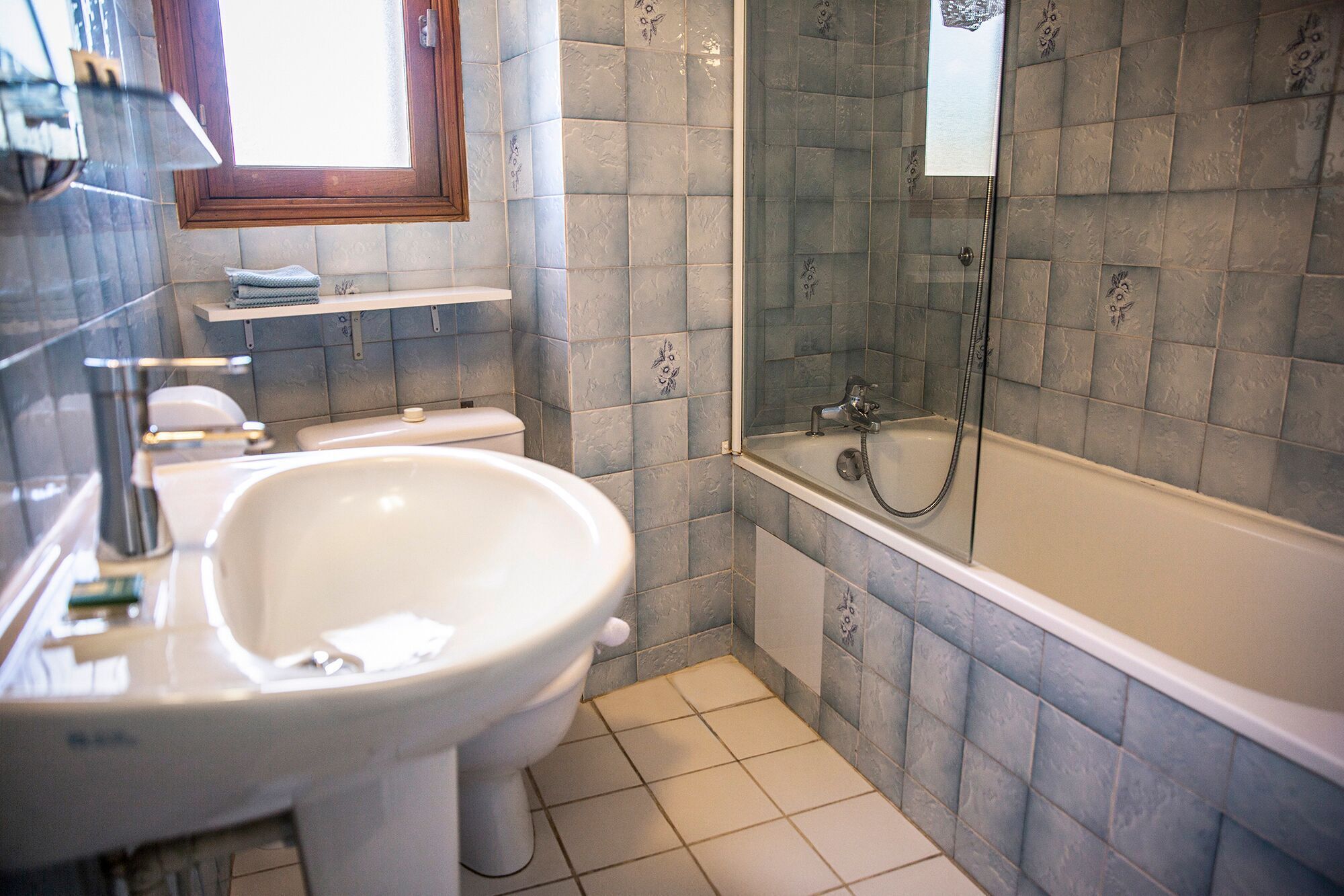 Une salle de bain avec un lavabo, des toilettes et une baignoire, le tout de couleur blanche.