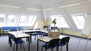 Un salón de conferencias con techo alto, tragaluces y diseño moderno.