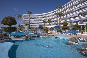 A hotel with a swimming pool, palm trees, and lounge chairs. - Hovima Atlantis (Adeje)