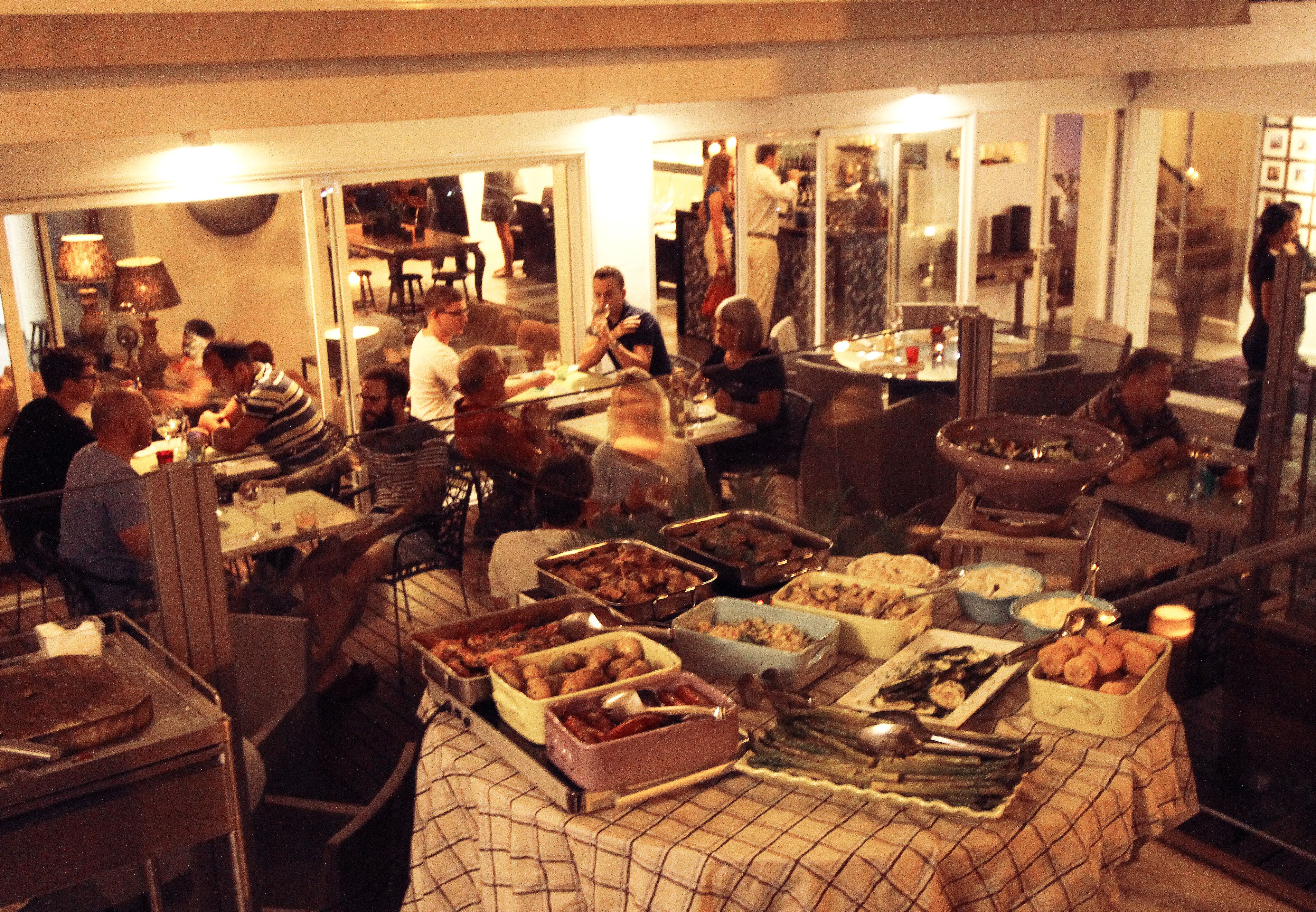 A buffet setup with various dishes and a crowd of people dining.