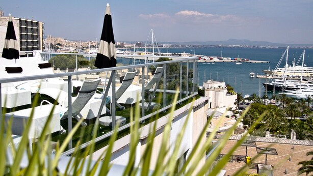 A high-rise building with a terrace overlooking a marina with boats and yachts. - Hotel Feliz (Palma de Mallorca)