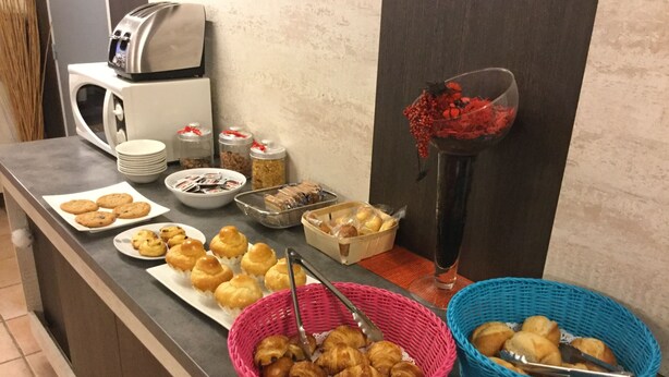 A buffet counter with various baked goods, including cookies, muffins, and croissants, arranged on plates and in baskets. - The Originals Access, Hôtel Béziers Est (Villeneuve-les-Beziers)