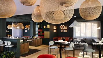 Enjoy meals in a stylish dining area with a central island, bar stools, and dining tables.