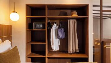 Habitación de hotel con un armario de madera, una cama, una mesita de noche y una lámpara colgante.