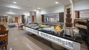 A buffet area with a variety of food items, including fruits, vegetables, and a chocolate fountain.