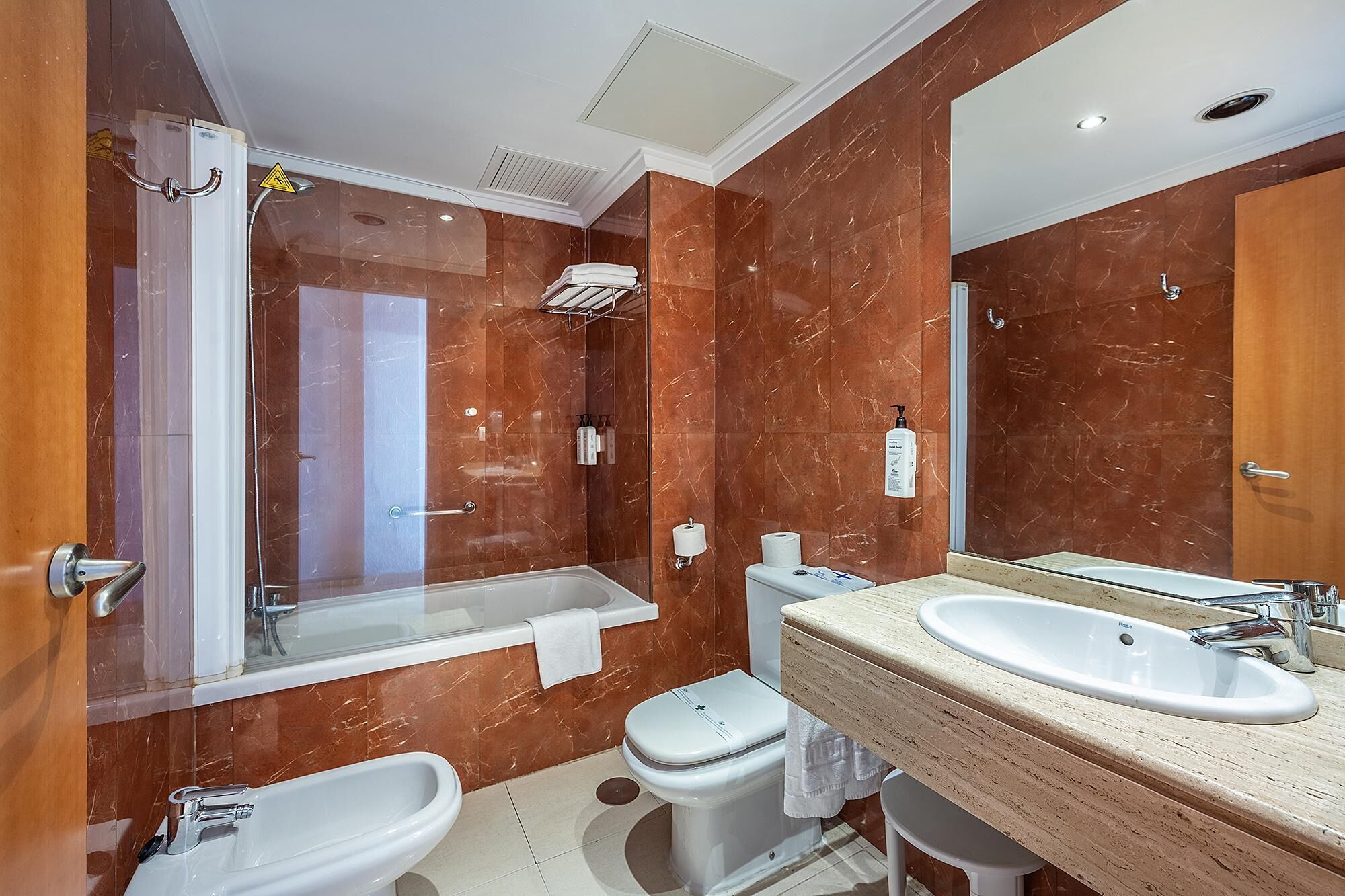 Un bagno moderno con doccia vetrata, un WC separato e un mobile lavabo.