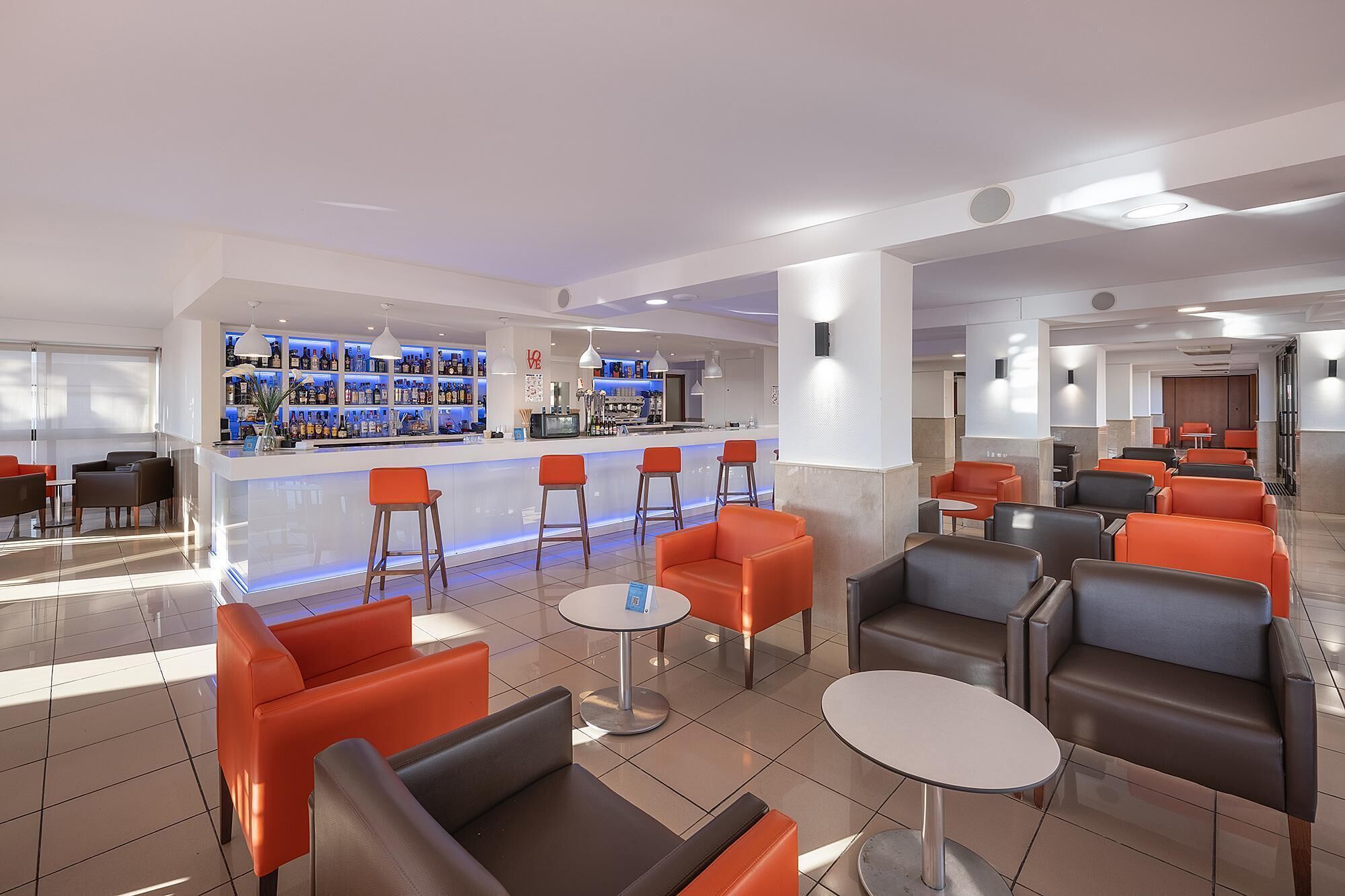 A modern bar area with seating and a bar counter.