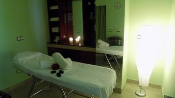 Cozy retreat with a single bed, mirror, and bedside table, set against a calming green wall.