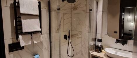 A modern bathroom with a toilet, bidet, and a glass-enclosed shower area.