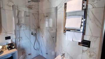 Ein modernes Badezimmer mit einer Duschkabine aus Glas, einem Standwaschbecken und einer Toilette.