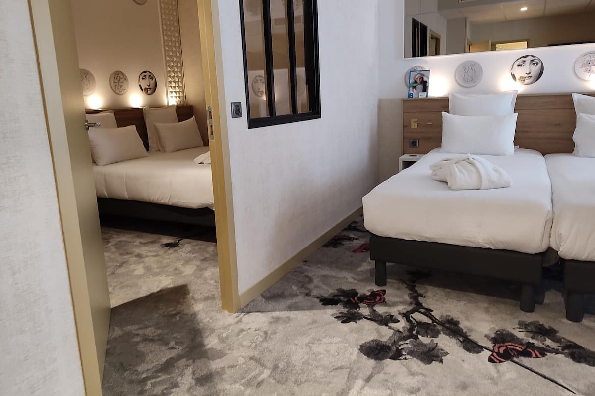 Une chambre d’hôtel avec un lit, une table de chevet et un miroir.