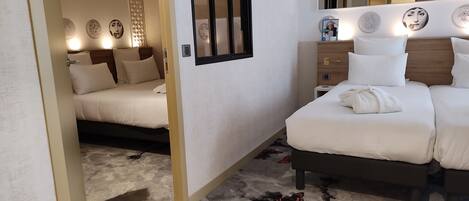 Una habitación de hotel con una cama, mesita de noche y un espejo.