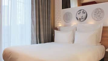 Una habitación de hotel con una cama grande, una ventana con cortinas y decoración en la pared.