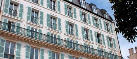Un edificio de varios pisos con balcones y persianas.